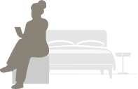 Hotel guest seated on bed